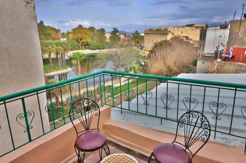 Dos sillas en un balcón con vista a un río. en Riad dar Saham, en Fez