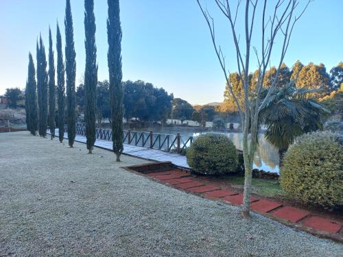 eine Reihe von Bäumen in einem Park neben einem Wasserkörper in der Unterkunft Palast Haus Pousada in Gramado