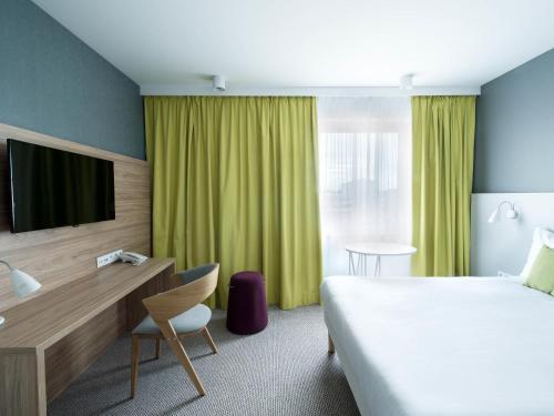 a hotel room with a bed and a tv at ibis Styles Siedlce in Siedlce