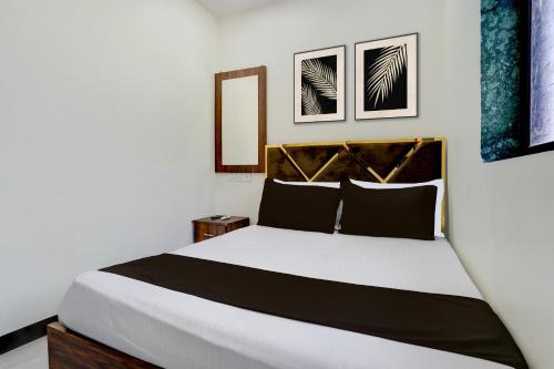 ein Schlafzimmer mit einem großen Bett mit zwei Bildern an der Wand in der Unterkunft Hotel O Jagruti Nagar Ghatkopar Formerly Icy Cool in Mumbai