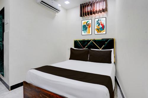 ein weißes Schlafzimmer mit einem weißen Bett mit schwarzen Kissen in der Unterkunft Hotel O Jagruti Nagar Ghatkopar Formerly Icy Cool in Mumbai