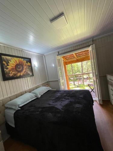 a bedroom with a bed in a room with a window at Morada Tito Georgi in Gramado