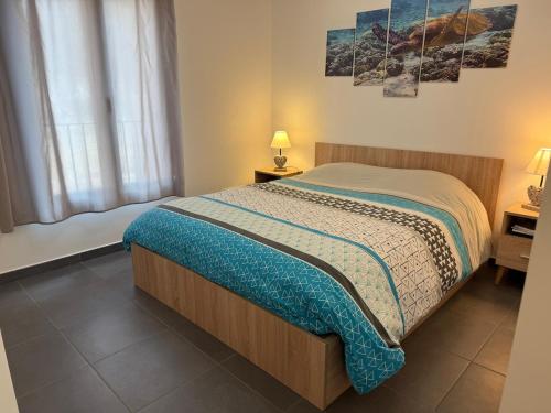 ein Schlafzimmer mit einem Bett und zwei Lampen und einem Fenster in der Unterkunft Edera - WiFi, TV, Piscine in Bonifacio