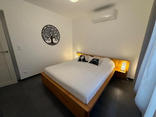 ein Schlafzimmer mit einem Bett mit einem Baumbild an der Wand in der Unterkunft Edera - WiFi, TV, Piscine in Bonifacio