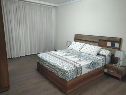 Banī Ghālibにあるكمبوند دلتا ستارزの木製のヘッドボードが付いたベッドのある寝室