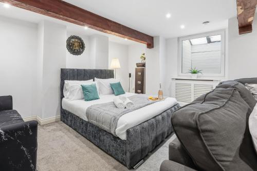 a bedroom with a large bed and a couch at The Snug in Bury