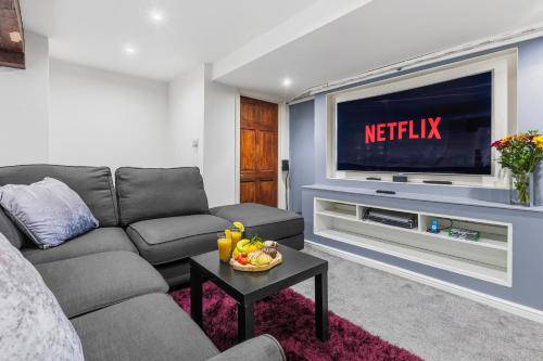 a living room with a couch and a television at The Snug- Ideal for Work & Leisure Stays in Bury