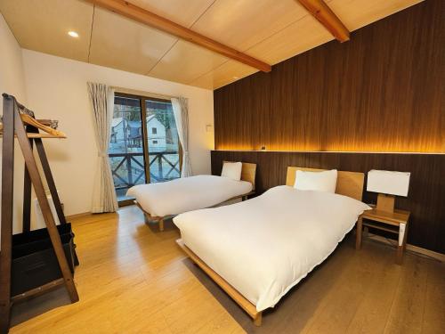 a bedroom with two beds and a ladder in it at Cozy Cove Hakuba in Hakuba