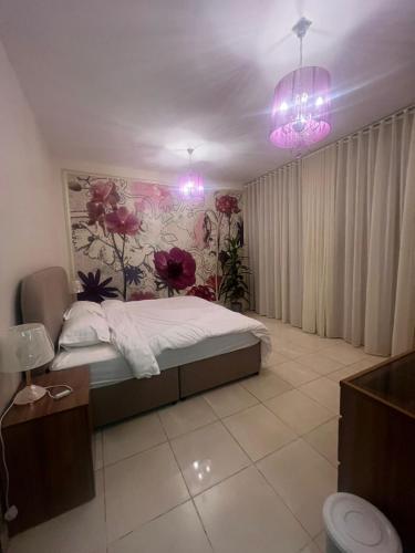 a bedroom with a bed and a floral wall at Lulu Luxury Apartment 1 one Bedroom in Al Khobar