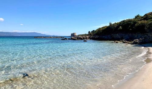 einen Strand mit blauem Wasser und einem Sandstrand in der Unterkunft Apartments in Alghero just 150 mt from the beach in Alghero