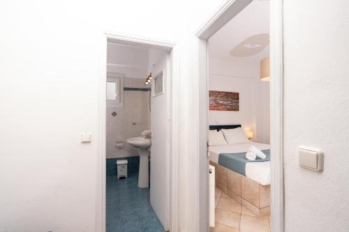 a bedroom with a bed and a bathroom with a sink at Cyclades Beach Apartments in Platis Gialos