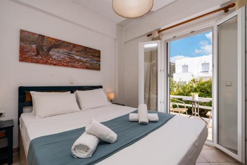 a bedroom with a bed with towels on it at Cyclades Beach Apartments in Platis Gialos