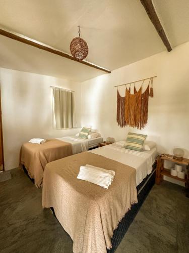 a room with two beds in a room at Indiana Kite school and Hostel in Cumbuco
