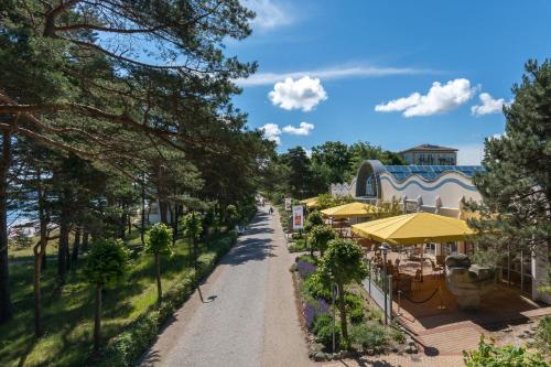 a dirt road with trees and a building at IFA Rügen Hotel & Ferienpark in Binz