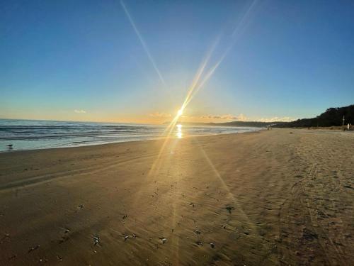 a beach with the sun shining on the sand at IFA Rügen Hotel & Ferienpark in Binz