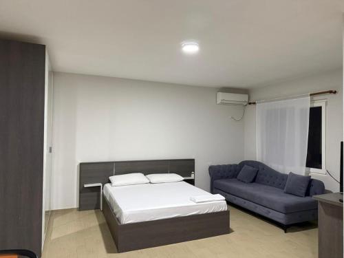 Un dormitorio con una cama y un sofá azul. en Rooftop Gallery Hostel, en Tirana