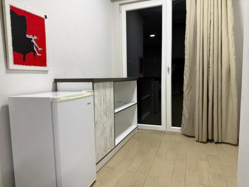 una cocina con encimera y refrigerador en Rooftop Gallery Hostel, en Tirana