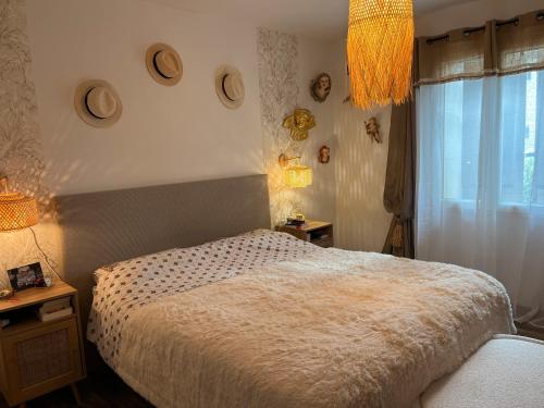 een slaapkamer met een bed en een raam met hoeden aan de muur bij Villa Rube in Coustellet