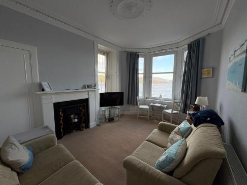 a living room with a couch and a fireplace at The Port in Port Bannatyne