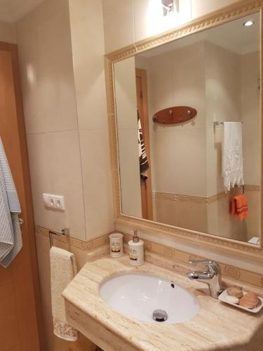 a bathroom with a sink and a large mirror at Brisas Cayetano in Cádiz