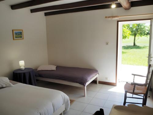 1 Schlafzimmer mit 2 Betten und einer Glasschiebetür in der Unterkunft Gite Le Fournil in Saint-Hilaire-la-Palud