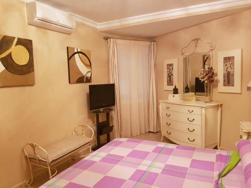 a bedroom with a bed and a dresser at Brisas Cayetano in Cádiz