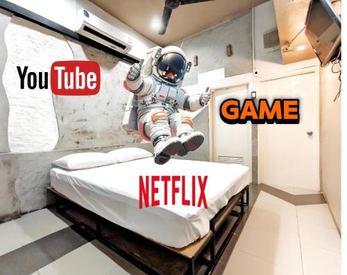 ein Zimmer mit einem Astronauten, der auf einem Bett herumspringt in der Unterkunft Hive28 in Bang Kapi