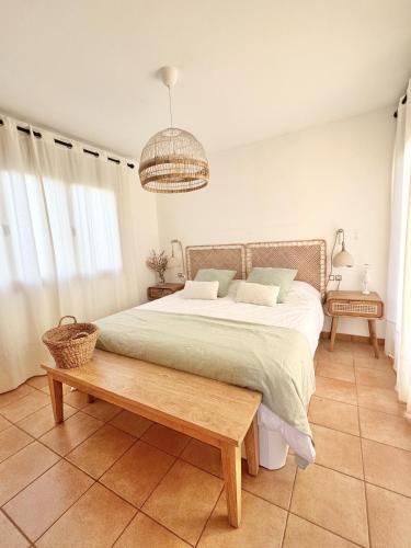 a bedroom with a large bed and a wooden table at Villa Majanicho Outside con piscina in Majanicho