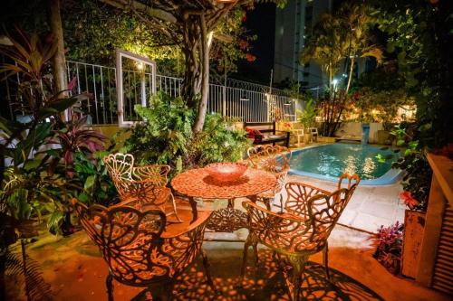 un patio avec une table et des chaises à côté d'une piscine dans l'établissement Pousada Flor de Ponta Negra, à Natal