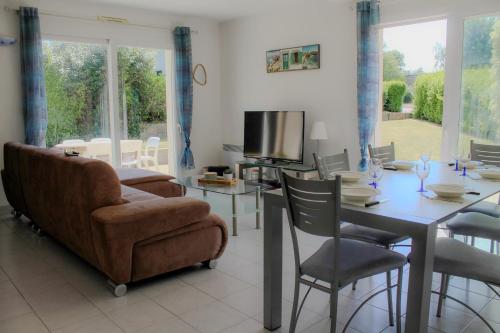 a living room with a table and a couch and a television at Ty Bénodet - Maison de vacances in Bénodet
