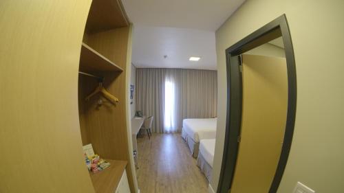 a hotel room with a bed and a mirror at Royal Tulip Holambra in Holambra