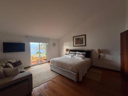 a bedroom with a bed and a couch at Bela Vigia in Jardim do Mar