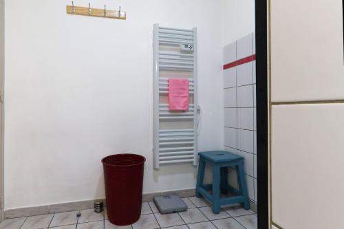 ein Badezimmer mit einem Mülleimer und einem blauen Hocker in der Unterkunft Gîte de NOE au Ray-pic in Péreyres