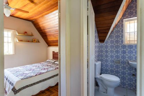 Un baño con una cama, un inodoro y un lavabo. en Sitio Rodeado de Verde c Piscina e Churrasqueira, en Cinco Lagos