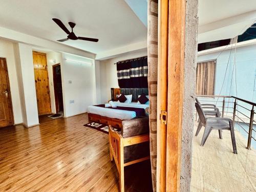 Un dormitorio con una cama y una silla en una habitación. en RV's Urban Nest - The City center Hotel, en Manali