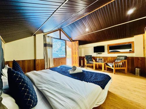 Un dormitorio con una cama grande y un comedor. en RV's Urban Nest - The City center Hotel, en Manali