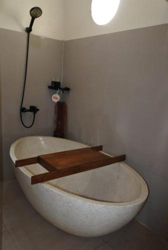 a large bath tub in a bathroom with a light at Lasakha Villa in Bantul