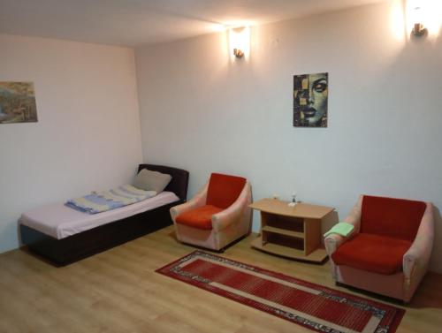 ein Wohnzimmer mit einem Bett und 2 Stühlen in der Unterkunft Z A M A K Vila in Vranje