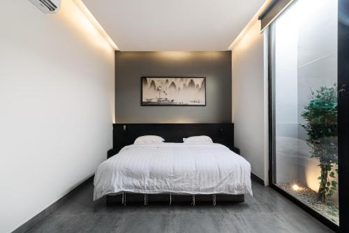 una camera da letto con un letto grande con lenzuola bianche di شاليهات روح نجد a Al ‘Ammārīyah