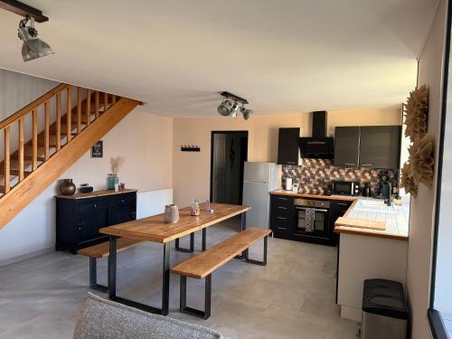 eine Küche mit einem Holztisch und einer Arbeitsplatte in der Unterkunft Maison aux pieds du circuit de Mirecourt in Baudricourt
