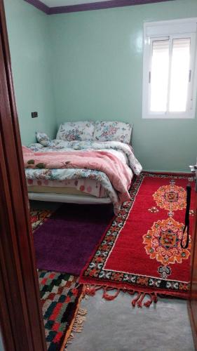 Berber Family的一间卧室配有一张红色地毯和窗户的床