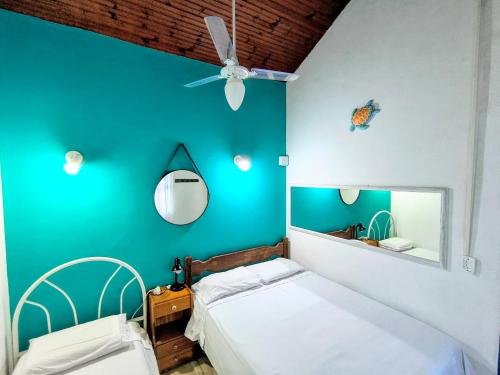 una camera da letto con una parete blu e 2 letti di Casa 12 Búzios Vilas a 500m da Rua das Pedras, top localização em condomínio lindo e calmo, portaria 24h a Búzios