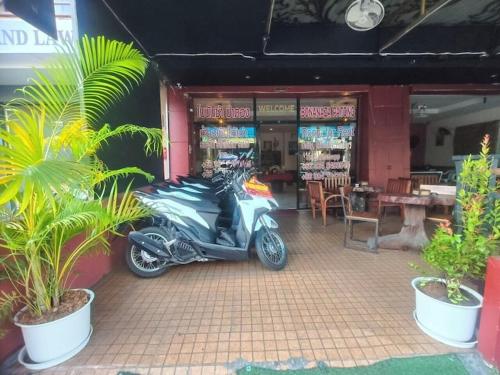 a motorcycle parked in front of a restaurant at Bursa Hotel Patong in Patong Beach