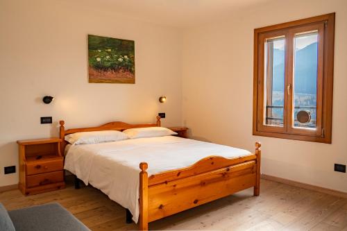 a bedroom with a wooden bed and a window at MH Luxury Apartments in Cavalese