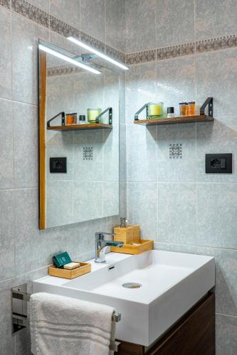 a bathroom with a white sink and a mirror at MH Luxury Apartments in Cavalese