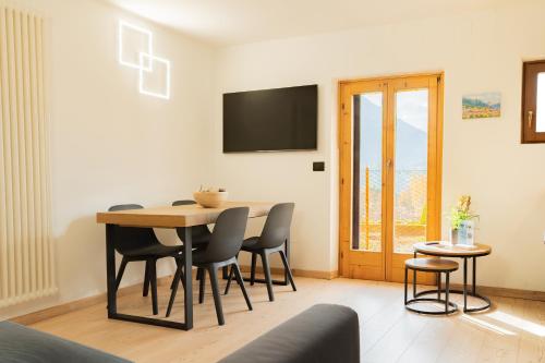 a dining room with a table and chairs and a television at MH-Luxury Apartments in Cavalese