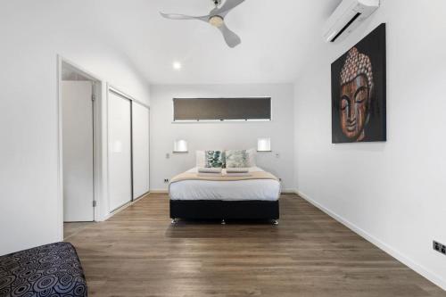 Balinese Style Villa With Bionized Pool في Bayview Heights: غرفة نوم بها سرير ومروحة سقف