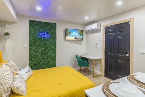 a bedroom with a yellow bed and a green wall at CUTE and COZY studio w jacuzzi in Orlando