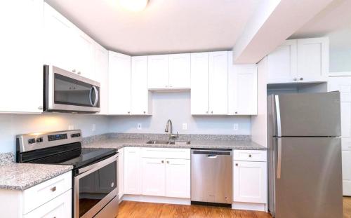 a kitchen with white cabinets and a stainless steel refrigerator at Budget Bed Room near Downtown Inner Harbor w Free Parking in Baltimore