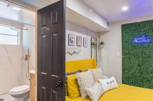 a bathroom with a yellow bed and a toilet at CUTE and COZY studio w jacuzzi in Orlando